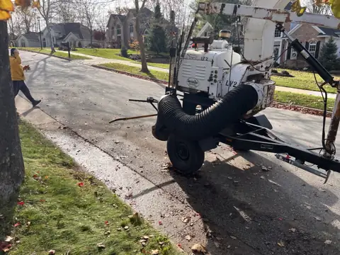 Leaf pickup equipment beside a cleared street edge
